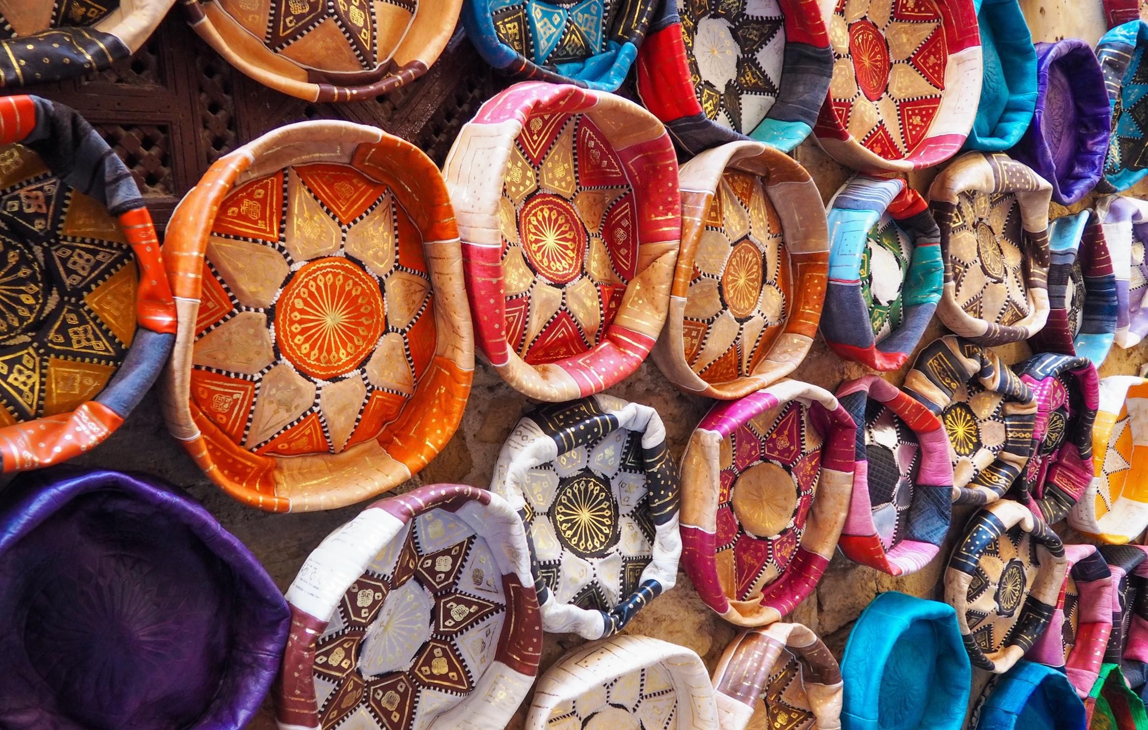 acliviaggi-marocco-colourful-leather-handcraft-bowl-shaped-souvenirs-displayed-traditional-souk-typical-street-morocco